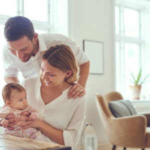 couple holding infant baby with help from postpartum in-home support